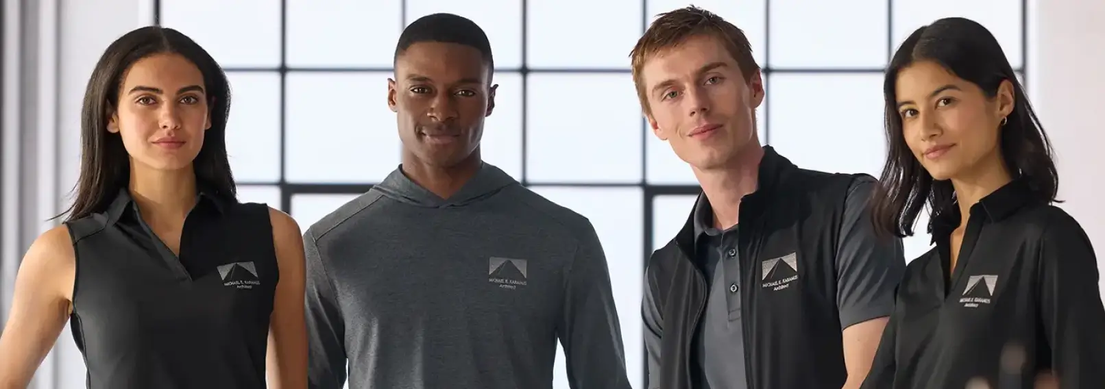 Four employees wearing matching branded uniforms as part of a managed employee uniform program